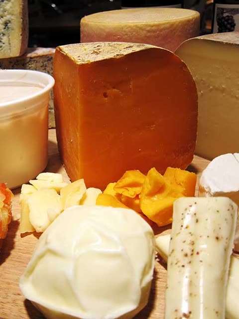 Assortment of cheeses on a wooden board.
