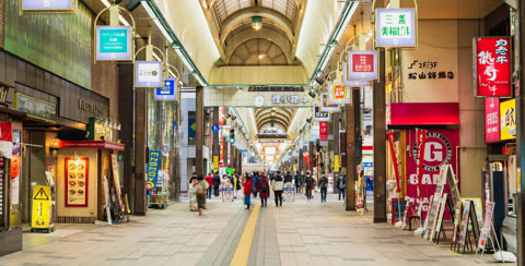 People walking through a covered shopping arcade.