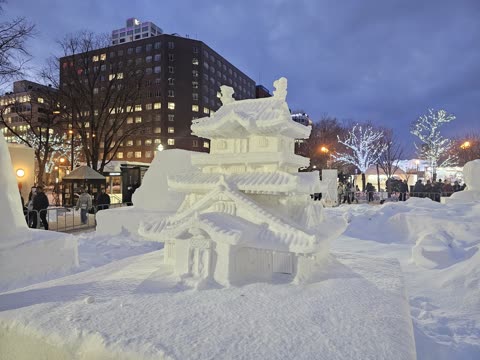 Snow castle replica at a twilight snow festival.